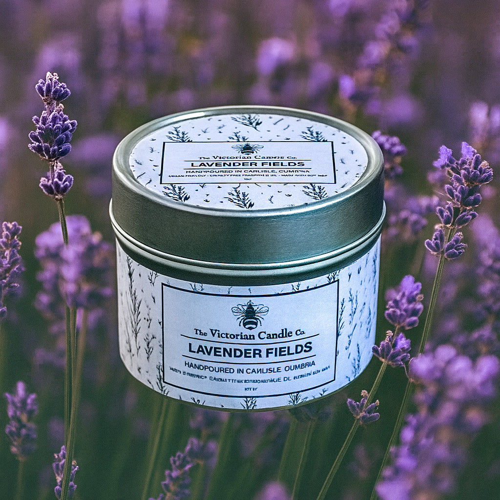 The Victorian Candle Co’s Lavender Fields – Scented Candle (100ml tin) rests among fresh lavender, featuring a floral-patterned tin and soft purple tones, highlighting its vegan-friendly formula.