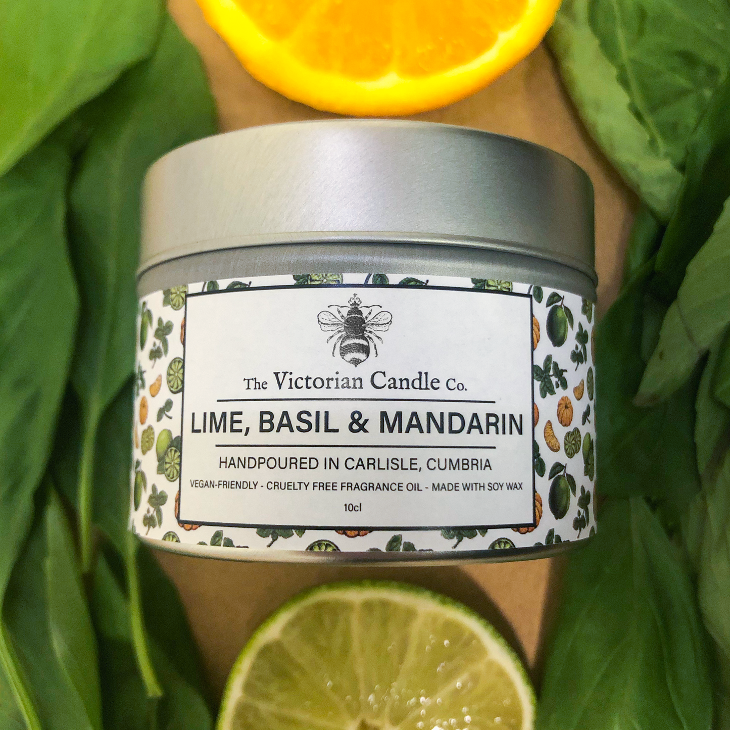 A Trio Box of Lime, Basil & Mandarin scented candles by The Victorian Candle Co. is beautifully complemented by fresh basil leaves and a sliced lime. These vegan-friendly soy wax candles are hand-poured in Carlisle, Cumbria, making them perfect for those who value artisanal craftsmanship.