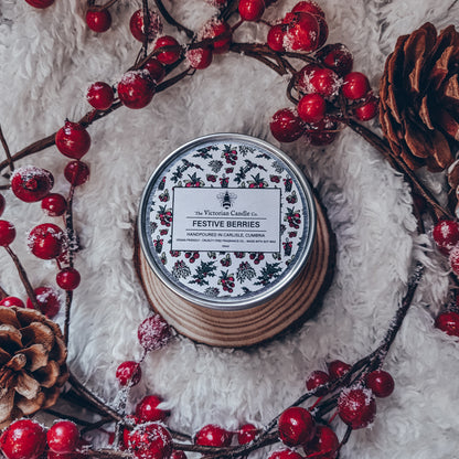 The Victorian Candle Co.'s Festive Berries - Scented Candle - 100ml Tin 🎅🏻 delivers a pleasant cranberry scent, surrounded by a charming arrangement of red berries, pinecones, and branches on a soft white background. Its tin is adorned with a berry and leaf motif and is made from eco-friendly soy vegan wax.