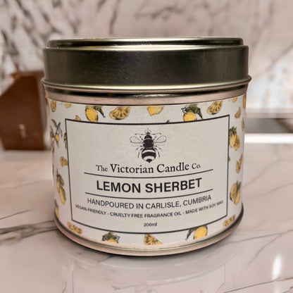 A 200ml tin candle from The Victorian Candle Co., named (Large) Lemon Sherbet - Scented Candle, features lemon and leaf illustrations that beautifully encapsulate the citrus essence. Hand-poured in Carlisle, Cumbria, this vegan-friendly and cruelty-free candle is infused with fragrance oil and crafted from soy wax.