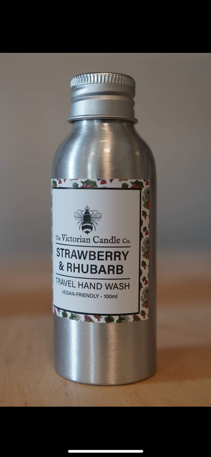 The Victorian Candle Co.'s Strawberry & Rhubarb Travel Hand Wash, packaged in a metal bottle adorned with bee imagery and decorative strawberry and rhubarb accents, offers a vegan-friendly solution for handwashing on the go, conveniently sized at 100ml.