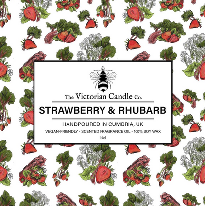 The background is adorned with strawberries and rhubarb patterns, centered by a label stating: The Victorian Candle Co. Strawberry & Rhubarb - Scented Candle - 100ml Tin. Made from soy vegan-friendly wax and packaged in recyclable tins, this fragrance is hand-poured in Cumbria, UK, providing an environmentally conscious aromatic experience.